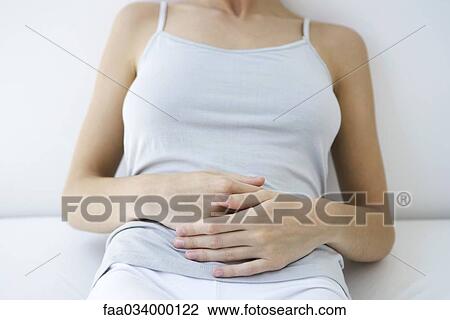 Woman holding stomach, cropped view View Large Photo Image Stock Image - Woman holding stomach, cropped view. Fotosearch