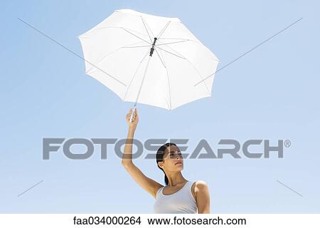 Woman holding up parasol, looking away View Large Photo Image Picture - Woman holding up parasol, looking away. Fotosearch