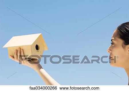 Woman looking at wooden birdhouse, cropped view View Large Photo Image Stock Photograph - Woman looking at wooden birdhouse, cropped view. Fotosearch