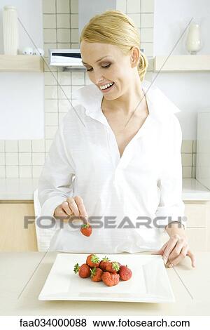 Stock Photo - Woman preparing plate of fresh strawberries. Fotosearch