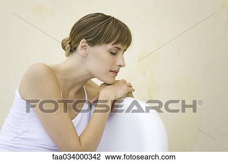 Woman seated, leaning against back of chair, eyes closed View Large Photo Image Stock Image - Woman seated, leaning against back of chair, eyes closed. Fotosearch