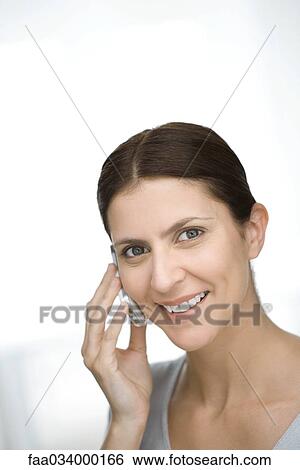 Stock Photograph - Woman using cell phone, smiling, portrait. Fotosearch