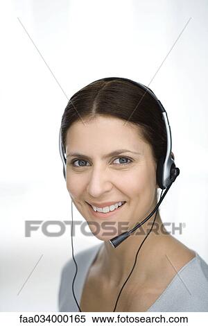 Woman wearing headset, smiling at camera, portrait View Large Photo Image Stock Photography - Woman wearing headset, smiling at camera, portrait. Fotosearch