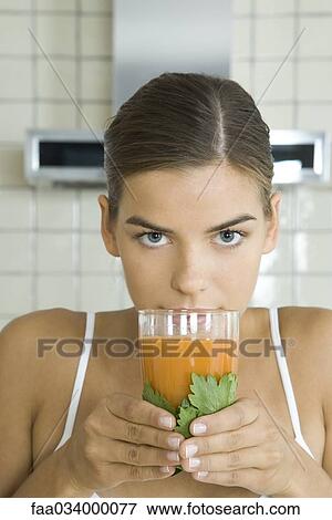 Stock Photo - Woman with glass of fresh carrot juice. Fotosearch