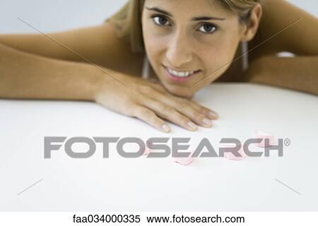 Woman with row of candy hearts, resting chin on hand, smiling at camera View Large Photo Image Stock Photography - Woman with row of candy hearts, resting chin on hand, smiling at camera. Fotosearch