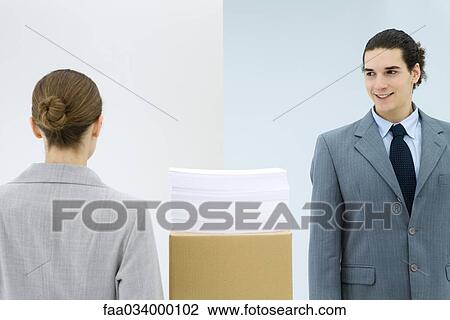 Young business associates walking pass each other in office View Large Photo Image Stock Image - Young business associates walking pass each other in office. Fotosearch