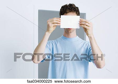 Young man holding blank index card in front of face View Large Photo Image Stock Photography - Young man holding blank index card in front of face. Fotosearch