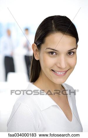 Stock Image - Young professional woman smiling at camera, portrait. Fotosearch
