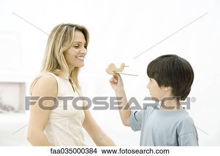 Boy showing his mother toy airplane, side view View Large Photo Image Picture - Boy showing his mother toy airplane, side view. Fotosearch