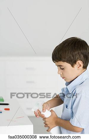 Boy spraying crayon scribbles with cleaning product View Large Photo Image Stock Photo - Boy spraying crayon scribbles with cleaning product. Fotosearch