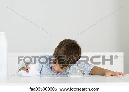 Boy wiping up spilled milk with towel View Large Photo Image Stock Photography - Boy wiping up spilled milk with towel. Fotosearch