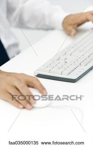 Businessman using keyboard and mouse, cropped view View Large Photo Image Stock Photography - Businessman using keyboard and mouse, cropped view. Fotosearch