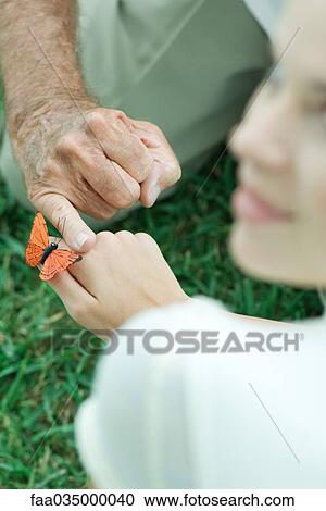 Butterfly landing on teenage girl's hand, man touching her hand with finger, over the shoulder view View Large Photo Image Stock Image - Butterfly landing on teenage girl's hand, man touching her hand with finger, over the shoulder view. Fotosearch