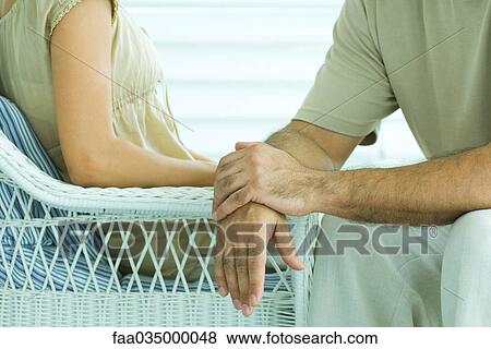 Couple sitting face to face, cropped view View Large Photo Image Stock Photo - Couple sitting face to face, cropped view. Fotosearch