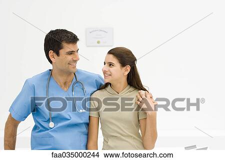 Picture - Doctor with arm around teenage girl's shoulder, smiling at each other. Fotosearch
