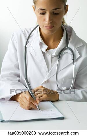 Doctor writing at desk View Large Photo Image Stock Image - Doctor writing at desk. Fotosearch