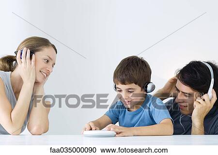 Stock Image - Family listening to portable CD player together. Fotosearch