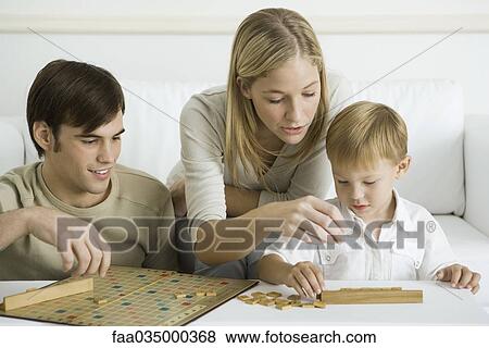 Stock Photo - Family playing board game together. Fotosearch