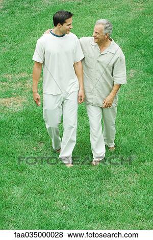 Stock Photo - Father and adult son walking together outdoors, high angle view. Fotosearch