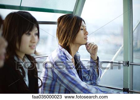 Stock Image - Friends taking ride on Ferris wheel at Tempozan Harbour Village, Osaka, Japan. Fotosearch