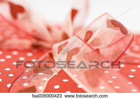 Gift wrapped with heart ribbon, extreme close-up View Large Photo Image Stock Image - Gift wrapped with heart ribbon, extreme close-up. Fotosearch