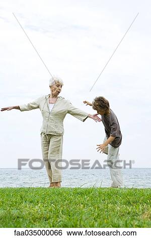 Grandmother helping grandson learn to balance on one leg View Large Photo Image Stock Photograph - Grandmother helping grandson learn to balance on one leg. Fotosearch