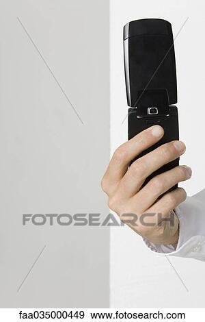 Hand holding flip cell phone View Large Photo Image Stock Photo - Hand holding flip cell phone. Fotosearch