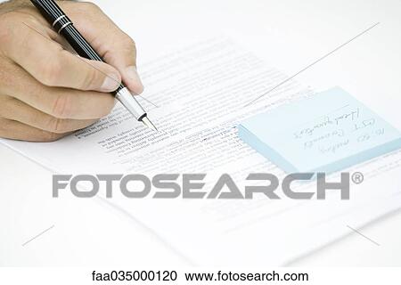 Stock Image - Hand holding pen, editing document. Fotosearch