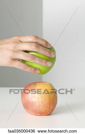 Hand selecting green apple, red apple in foreground View Large Photo Image Stock Photograph - Hand selecting green apple, red apple in foreground. Fotosearch