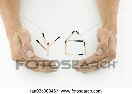 Hands protecting burnt matches arranged in shape of house and tree View Large Photo Image Stock Photo - Hands protecting burnt matches arranged in shape of house and tree. Fotosearch