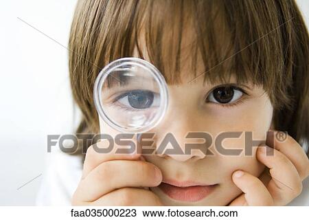 Little boy looking through magnifying glass at camera View Large Photo Image Stock Image - Little boy looking through magnifying glass at camera. Fotosearch