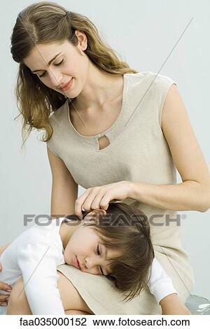 Little boy lying in mother's lap, woman stroking son's hair View Large Photo Image Stock Image - Little boy lying in mother's lap, woman stroking son's hair. Fotosearch