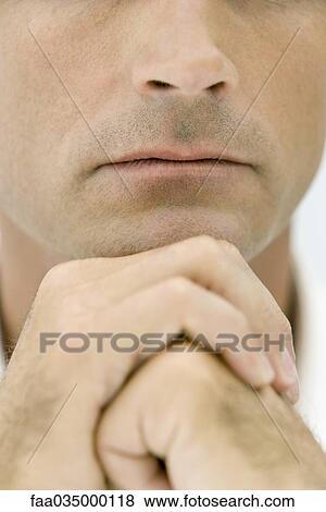 Man holding hands together under chin, cropped view View Large Photo Image Stock Photo - Man holding hands together under chin, cropped view. Fotosearch