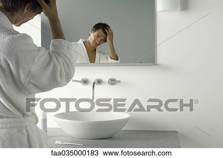 Man holding head, frowning at himself in mirror View Large Photo Image Stock Image - Man holding head, frowning at himself in mirror. Fotosearch
