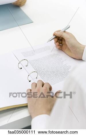 Man reviewing document in binder, over the shoulder view, cropped View Large Photo Image Stock Image - Man reviewing document in binder, over the shoulder view, cropped. Fotosearch