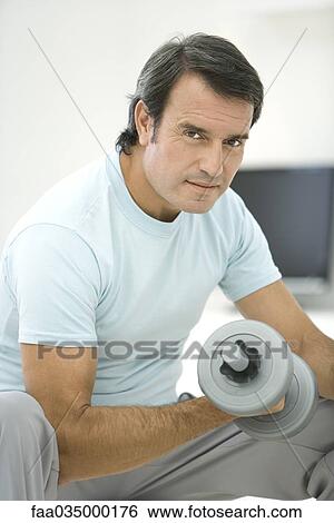 Mature man lifting dumbbell, looking at camera View Large Photo Image Stock Photograph - Mature man lifting dumbbell, looking at camera. Fotosearch