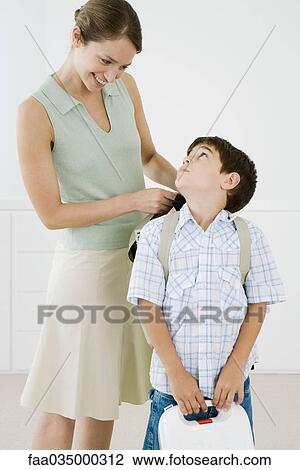 Mother adjusting son's backpack, boy looking up at her View Large Photo Image Stock Image - Mother adjusting son's backpack, boy looking up at her. Fotosearch
