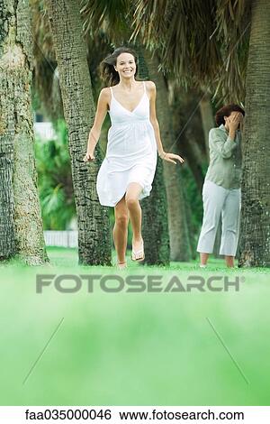 Mother and teen daughter playing hide-and-seek in park, girl running toward camera View Large Photo Image Stock Photograph - Mother and teen daughter playing hide-and-seek in park, girl running toward camera. Fotosearch