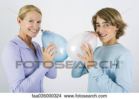Mother and teen son inflating balloons, smiling at camera View Large Photo Image Picture - Mother and teen son inflating balloons, smiling at camera. Fotosearch