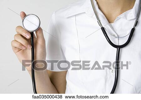 Nurse holding stethoscope, cropped view View Large Photo Image Stock Photo - Nurse holding stethoscope, cropped view. Fotosearch