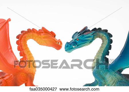 Orange toy dragon facing blue toy dragon, side view View Large Photo Image Stock Photo - Orange toy dragon facing blue toy dragon, side view. Fotosearch