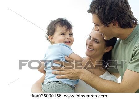 Parents embracing toddler, all smiling View Large Photo Image Stock Photograph - Parents embracing toddler, all smiling. Fotosearch