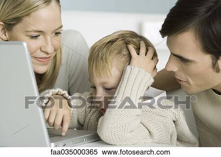 Parents helping little boy use laptop computer, close-up View Large Photo Image Stock Photography - Parents helping little boy use laptop computer, close-up. Fotosearch