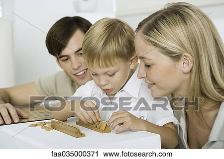 Parents watching as little boy arranges game pieces View Large Photo Image Stock Image - Parents watching as little boy arranges game pieces. Fotosearch