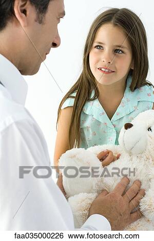 Pediatrician with young patient, girl holding teddy bear View Large Photo Image Stock Photograph - Pediatrician with young patient, girl holding teddy bear. Fotosearch