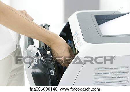 Stock Image - Person fixing printer, cropped view. Fotosearch