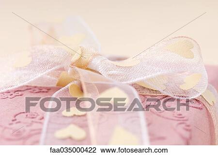 Pink gift wrapped with heart ribbon, extreme close-up View Large Photo Image Stock Image - Pink gift wrapped with heart ribbon, extreme close-up. Fotosearch
