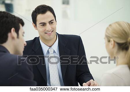 Professional man face to face with couple, smiling View Large Photo Image Stock Photo - Professional man face to face with couple, smiling. Fotosearch