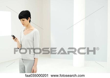 Professional woman looking at cell phone View Large Photo Image Stock Image - Professional woman looking at cell phone. Fotosearch