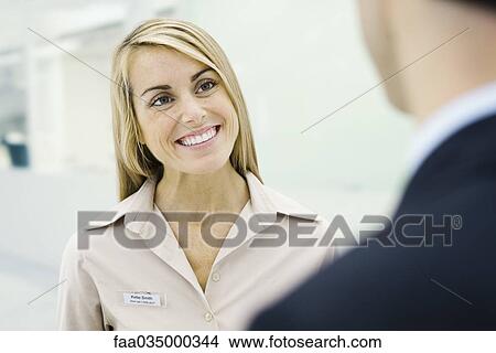 Professional woman smiling at man, cropped view View Large Photo Image Picture - Professional woman smiling at man, cropped view. Fotosearch